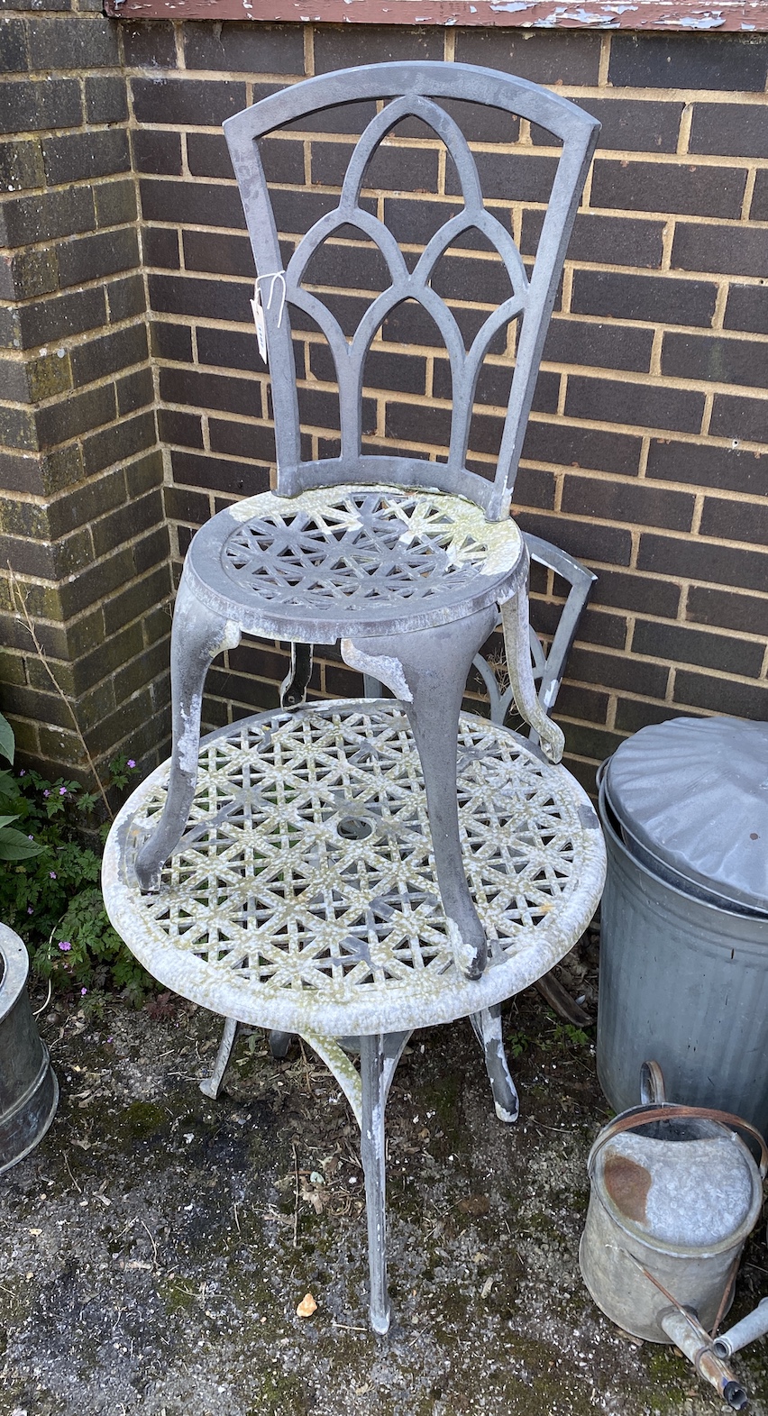 An aluminium circular garden table, 66cm diameter, and a pair of chairs